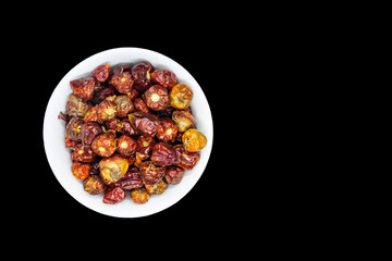 A bunch of round red chillies in white bowl in a nice wooden background