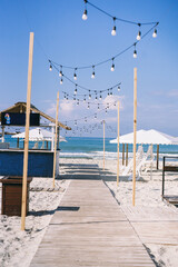 beautiful beach. with a wooden walkway, thatched roof gazebo and beautiful white umbrellas
