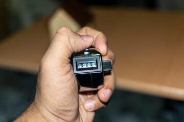 a man hand holding counting machine