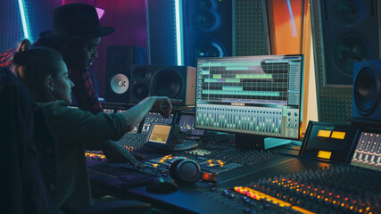 Producer and Professional Audio Engineer Working together in Music Recording Studio on a New Album,...