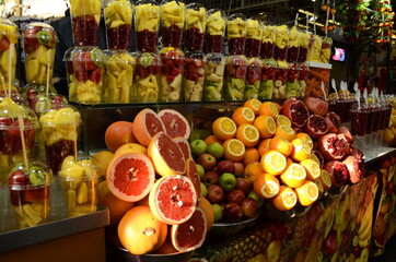 Juice Bar on the market - Pomegranates and oranges. Glasses with peeled pomegranate and pineapple.