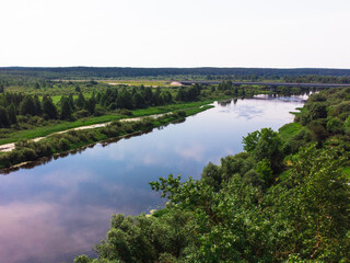 Fototapeta na wymiar river with blue water surrounded by green trees. the view from the top. summer time