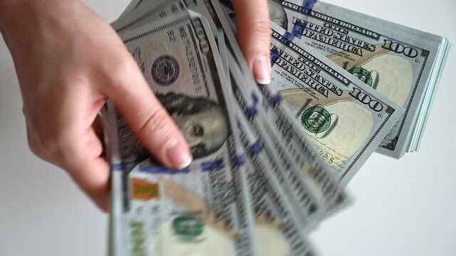 Man hand counting us dollars with nominal of 100, slow motion close up