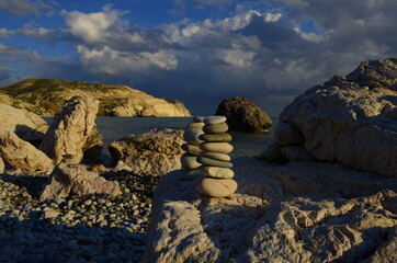 Fototapeta na wymiar Paphos. Cyprus. Petra tou romiou. Aphrodite's rock. View from the postcard dramatic stormy sky over the sea. Rocks in the sea. The birthplace of the goddess Aphrodite. Romantic beach for lovers. 