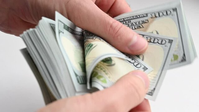 Man hand counting us dollars with nominal of 100, slow motion close up