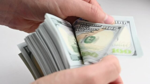 Man hand counting us dollars with nominal of 100, slow motion close up