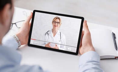 Health blog. Man in shirt watching medical video with woman doctor on tablet