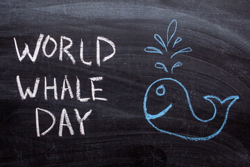 world whale day text on a chalkboard. Drawing of a whale in blue chalk