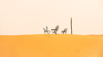 Naklejka premium Chairs and table in the sand of the desert