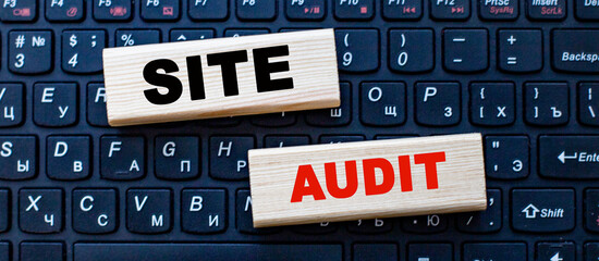 SITE AUDIT is written on wooden blocks that lie on a computer keyboard. Internet technologies....