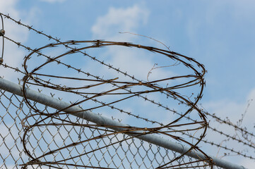 Barbed wire and concertina razor wire on fence