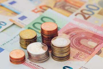 Columns of euro coins close up of euro banknotes. The concept of economics and finance. The background is blurred.