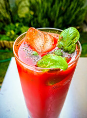 Tomato juice with ice and basil outside