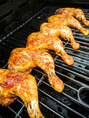 Six golden chicken legs on the grill
