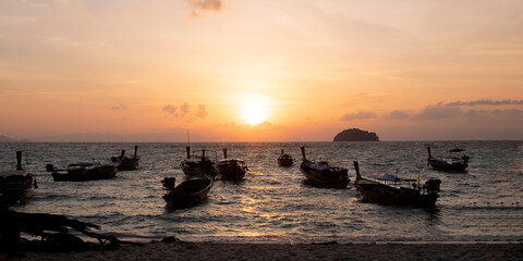Fototapeta na wymiar Seashore in the moment of sunset is surrounding by Thailand taxi boats.