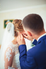 girl in a white dress at home. Bride with makeup. Wedding. Preparing the bride for the upcoming wedding.