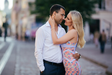Fototapeta premium walking down the street together. Happy young man and smiling woman walking through the streets of Old Town,