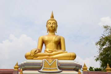 The golden statue of the buddha statue in the sky background
