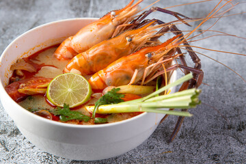 Thai food, Tom Yum Kung in a white cup on a stone pattern