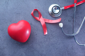 Red ribbon HIV, heart and stethoscope on black background. - obrazy, fototapety, plakaty