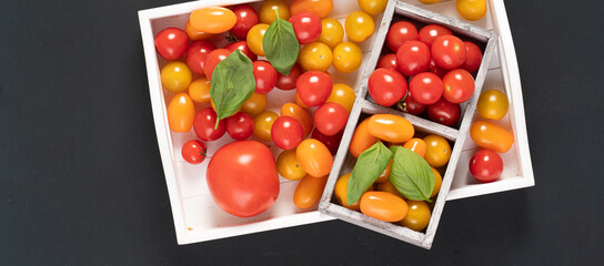 fresh italian cherry tomatoes on the vine in a wooden crate on a white background