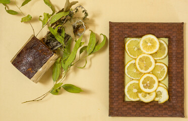 composición decorativa ,cuadro con rodaja de limones y bote natural con plantas secas 