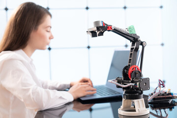 Woman student with robot model arm