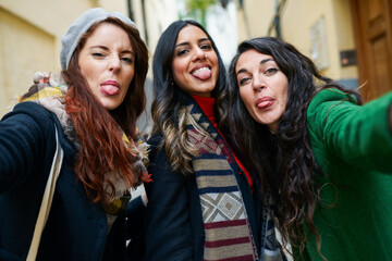 Fototapeta premium Group of woman taking a selfie photo sticking out their tongues