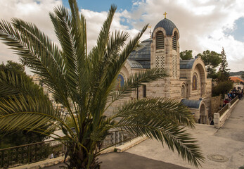 Fototapeta na wymiar View of the palm tree and further on St. Peter's Church in Gallicantu on Zion Mount in Jerusalem, area of the Old City