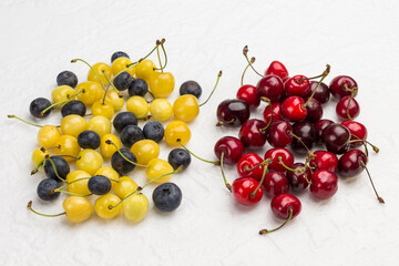Naklejka na ściany i meble Red cherry, yellow cherry and blueberry on white background