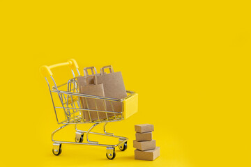 Paper bags in the shopping basket, brown paper boxes next to the basket. The concept of buying or...