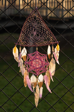 Purple mandala dream catcher with feathers on street