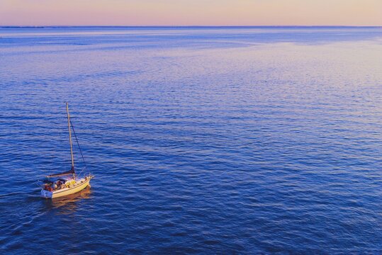 Sailboat challenge the sea, aerial view landscape from above. Yacht sailing boat from drone on opened sea. Yachting at windy day in blue ocean water. Summer vacation, travel adventure, nature concept.