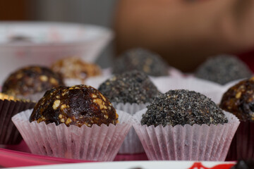 Dried fruit sweets. Balls of prunes, dates and coconut. With a sprinkle of black sesame powder.