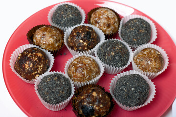 Dried fruit sweets. Balls of prunes, dates and coconut. With a sprinkle of black sesame powder.