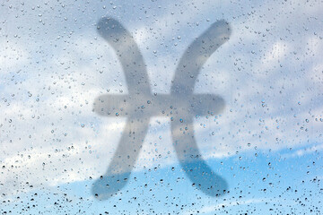 Water signs of the zodiac. Three astrological symbols - cancer, scorpion and pisces. Drawing a finger on the misted glass. Glass window with raindrops against the sky. - 359036318