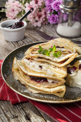 Crepes with ricotta cheese and blackcurrant jam.