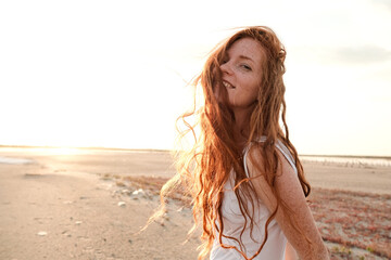 Beautiful young lady with long healthy red hair and cute dress