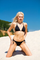 Full body portrait of a young beautiful woman in black bikini