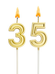 Burning golden birthday candles on white background, number 35
