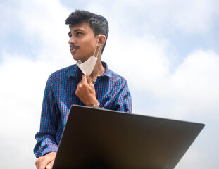 Teen man working in laptop and looking stressful.man with protective face mask.