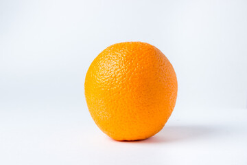 One orange on a white background. A whole orange in a peel.