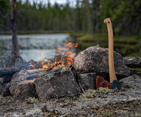 Axe and campfire scene in the back country, Canadian wilderness 