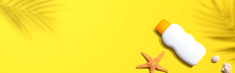 Sunblock bottle starfish and seashells - flat lay