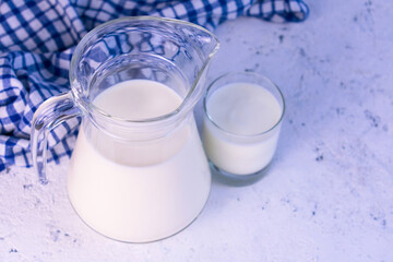 Carafe and glass with milk on a white background. Top view.