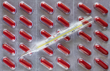 Blisters with pills and a thermometer