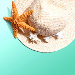 Fototapeta na wymiar Summer concept with a straw hat and starfish overhead view - flat lay