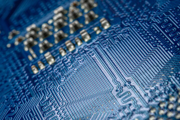 Macro photo of electrical paths on blue circuit board, selective focus.