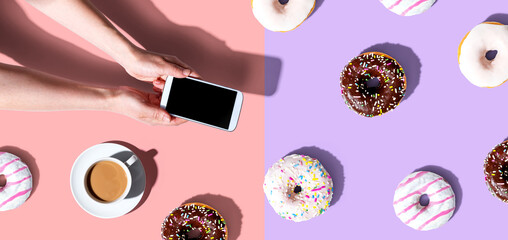 Person using a smartphone with donuts from above