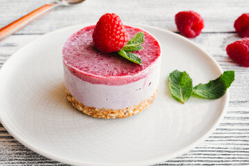  Raspberry cake with nuts, on a white wooden background. Raw dessert